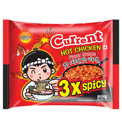 A red packet of Current Hot Chicken Flavor Ramen by Yashoda Foods. The packet features a cartoon character eating ramen and a warning that it is 3x spicy.