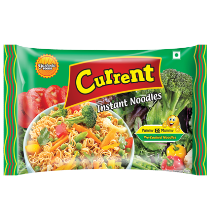 A green packet of Current Instant Noodles by Yashoda Foods. The packet shows a colorful bowl of noodles with vegetables like tomatoes, broccoli, and peas. The text "Yummy Mommy" and a smiling cartoon character are printed on the packet.