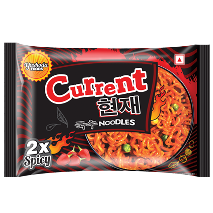 A red and black packet of Current 2x Spicy Korean Noodles by Yashoda Foods. The packet features flames and chili peppers, indicating the extra spicy flavor.